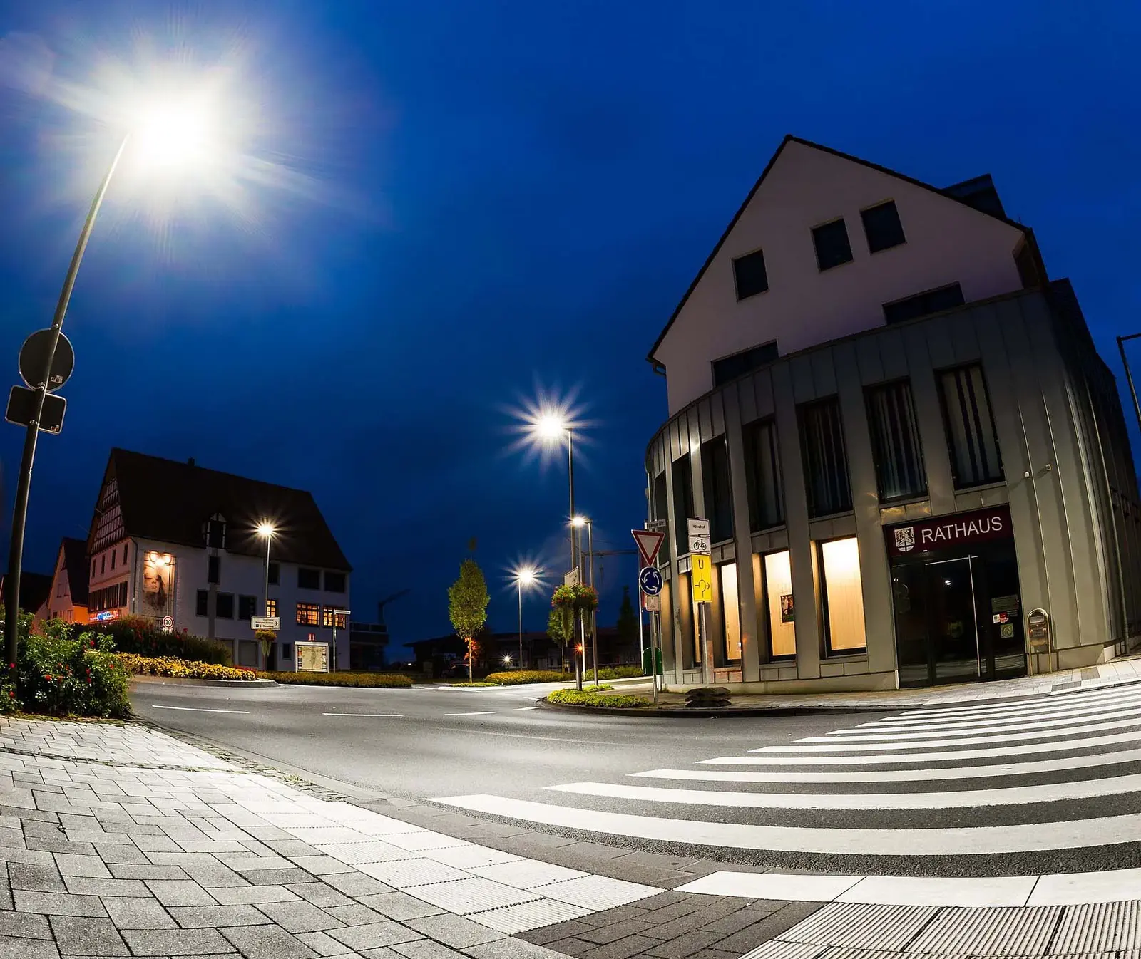 Straßenbeleuchtung vor einem Rathaus bei Nacht